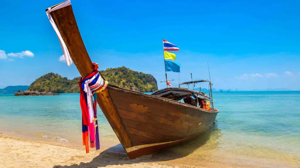 Thai traditional wooden longtail boat at tropical beach in Thailand