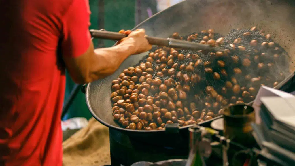 a man worker roasting chestnuts in street chinatown or Yaowarat Road in Bangkok